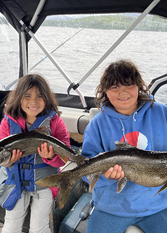 Boy and girl holding fish