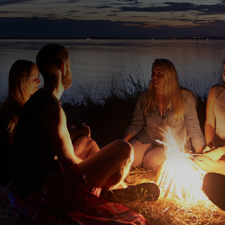Friends camping fire late night