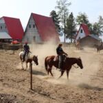 People riding horse near cabin 150x150