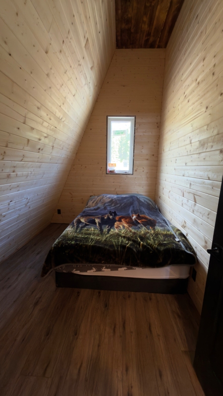 Wood-paneled bedroom at Sustutdene Eco Resort